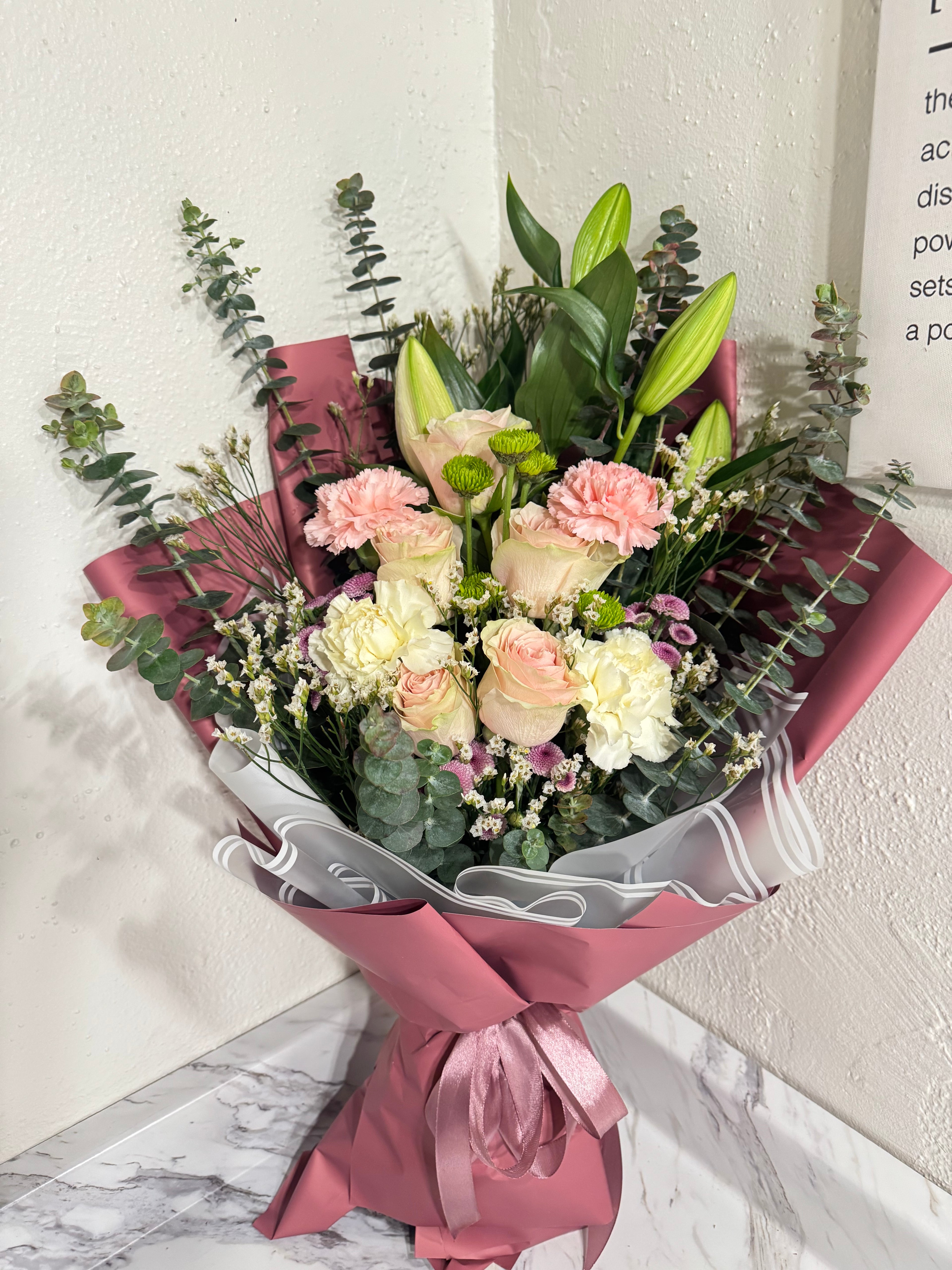 Bouquet of flowers with pink ribbon on a marble surface